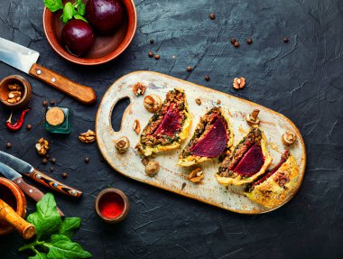 Mutfak tahtasına dilimlenmiş leziz pancar turtası. Wellington turtası.