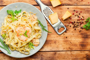 Tahta masadaki karidesli Fettuccini makarna. İtalyan yemeği.