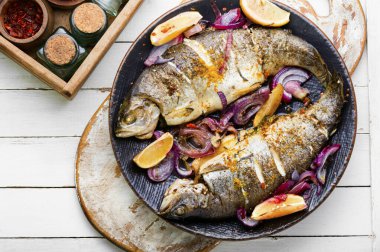 Tabağında limon olan kızarmış alabalık.