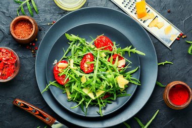 Güneşte kurutulmuş domates ve bitkilerle salata. Mutfak masasında parlak sebze salatası.