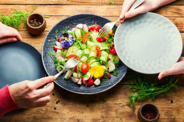 Salatalık, domates, turp ve yenebilir çiçeklerle süslenmiş yeşil salata. Vitamin salatası.