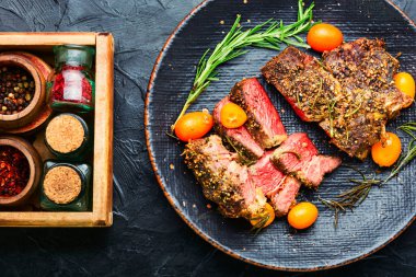 Dilimlenmiş biftek, kumkat, biberiye ve baharatla kavrulmuş. Tabakta dana eti.