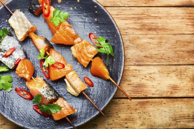 Tahta şişler üzerinde kurutulmuş tuzlu somon parçaları.