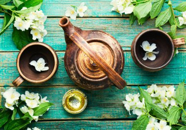 Kil çay fincanları ve çaydanlık. Yasemin çiçeği çayı. Bitki çayı.