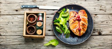 Kızarmış tavuk göğsü ve kiraz sosu. Böğürtlenli tavuk eti. Eski ahşap masada.