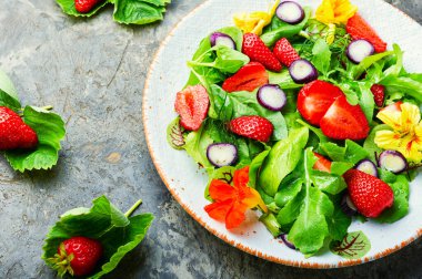 Çilekli vitamin salatası, ıspanak, nasturtium ve roka. Sağlıklı organik diyet salatası.