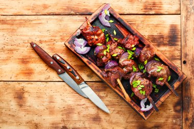 Ahşap şişte soğanlı ızgara ciğer kebabı.