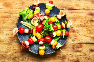 Açık büfe karides, jamon, meyve ve sebzeler ahşap şiş üzerinde.