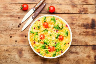 Brokolili sebze güveci, domates ve balkabağı eski ahşap masada. Frittata.