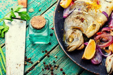 Soğan ve limonla kızartılmış balık. Kırsal ahşap masada pişmiş gökkuşağı alabalığı