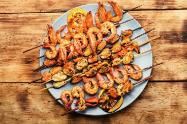 Tahta bir şişte kızartılmış iştah açıcı karidesler. Izgara deniz ürünleri.