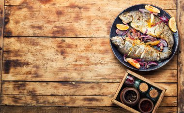 Soğan ve limonla kızartılmış balık. Fırınlanmış gökkuşağı alabalığı, deniz ürünleri. Boşluğu kopyala.