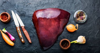 Mutfak masasında çiğ sığır ciğeri var. Pişmemiş taze ciğer.