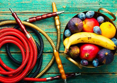 İncir, mango, muz ve erik tadında nargile içmek. Meyve aromalı tütün nargilesi..