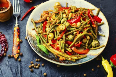 Biber, kuşkonmaz, fasulye, domates ve kapariden yapılan baharatlı sebze aperatifi.