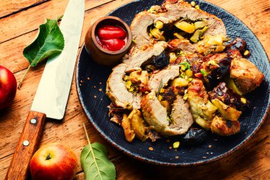 Fırında domuz eti, hurma, elma ve fıstık. Kızarmış yağsız domuz eti. Tahta masada doldurulmuş domuz eti.