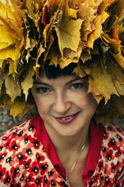 Menina com uma grinalda de folhas de bordo de outono — Fotografia de Stock