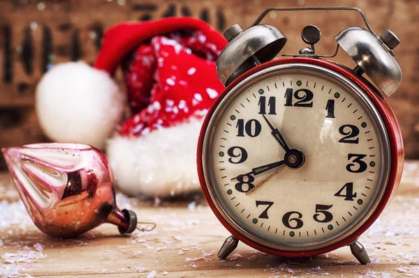 Old-fashioned alarm clock and red Christmas cap — Stock Photo, Image