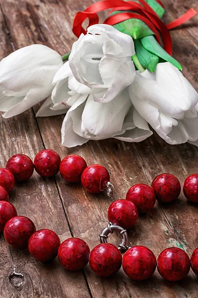 Tulips and womens coral beads — Stock Photo, Image