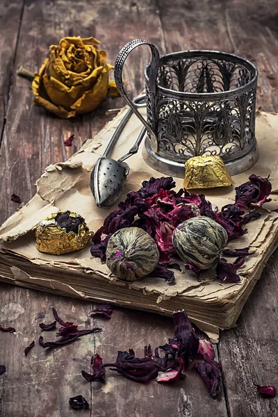 Tea accessories amid frayed books — Stock Photo, Image