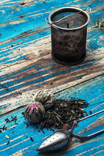 Kuru çay çeşitli yeşim yığınlarda ahşap arka plan üzerinde bırakır. — Stok fotoğraf