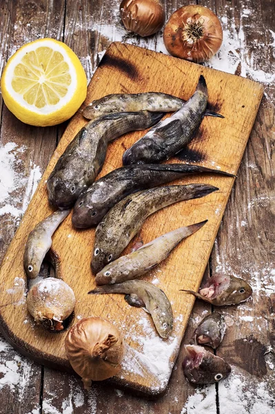 Färsk fisk innan du koka den på en skärbräda med kniv — Stockfoto
