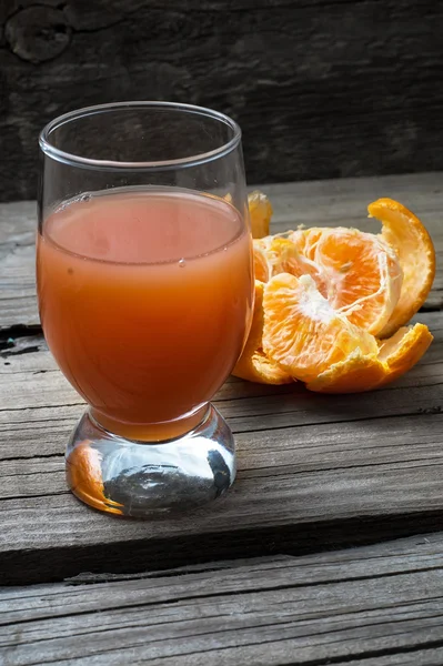 Fresh juice of tropical citrus fruits on wooden background — Stock Photo, Image