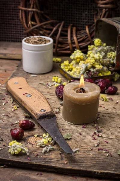 Medicinal herb and burning candle — Stock Photo, Image