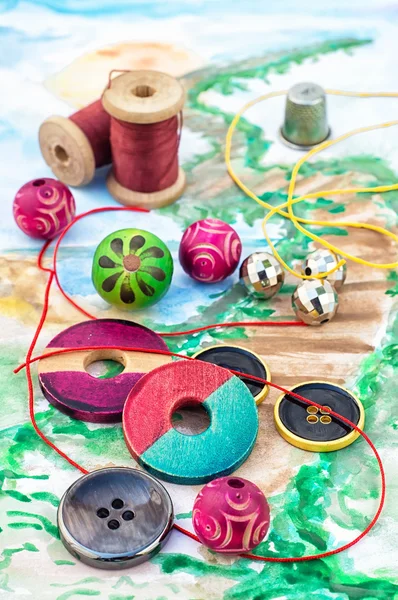 Threads and embellishments on a colorful background — 图库照片