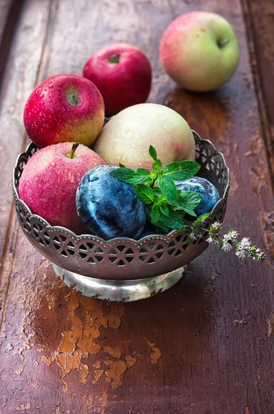 Äpfel und Pflaumen in eiserner Vase — Stockfoto