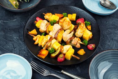 Platter of grilled meat skewers featuring vibrant and juicy pineapple