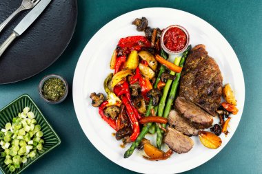 Grilled duck breast seasoned with spices and vegetables, healthy food and barbecue. Overhead view.