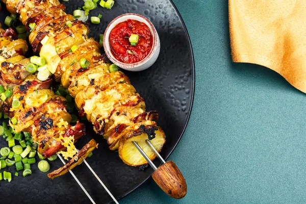 Potato and bacon skewers with cheese, sauces on a skewers, barbecue.