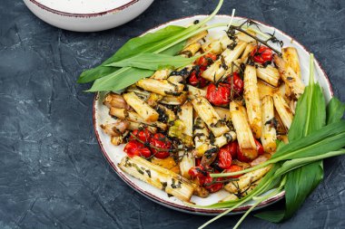 Roasted spring vegetables - asparagus with tomatoes and wild garlic. Grilled salad.