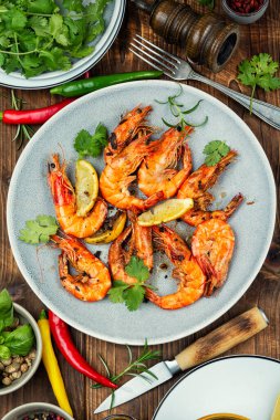 Biber ve limon dilimli baharatlı Langoustines. Kavrulmuş Langoustine karidesleri. Deniz ürünleri mangalı..