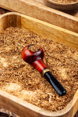 Masasında tütün olan ahşap pipo. Eski model. Pipo tütünü içiyorum.