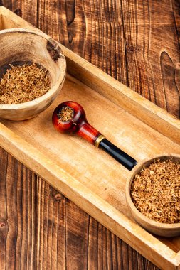 Sigara piposuyla gevşeme kompozisyonu, ahşap kırsal arka planda tütün piposu.