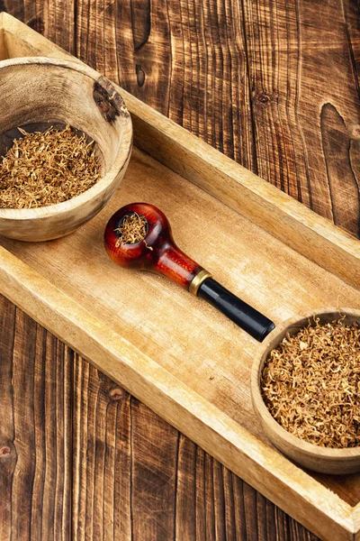 Sigara piposuyla gevşeme kompozisyonu, ahşap kırsal arka planda tütün piposu.