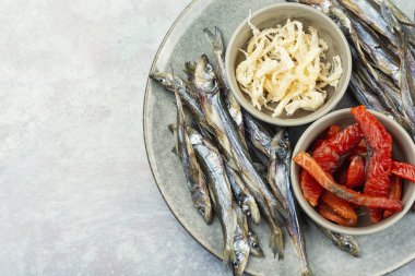 Beer and assorted dried fish on a cooking sheet, traditional beer snack. Smoked salmon for beer. Copy space.
