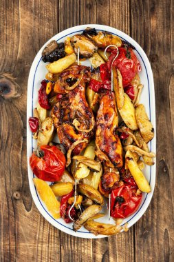 Dolmalık biberler, fırında patatesler ve mantarlarla süslenmiş lezzetli ızgara et şişleri. Kırsal biçim.