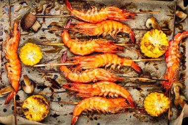 Izgara deniz ürünleri, kızarmış Langoustines ve ahşap şişte kızarmış mısır. Barbekü.