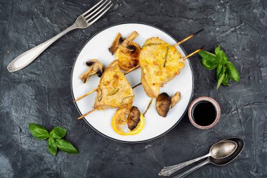 Mükemmel kurutulmuş ton balığı bifteği ve mantarlı şiş. Beton mutfak masasında balık tabağı..