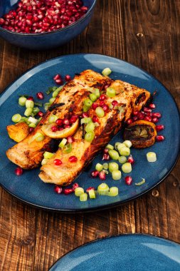 Öğle yemeği için sağlıklı yemek, taze pişmiş iki ızgara balık bifteği ya da ahşap yüzeyde kırmızı somon..