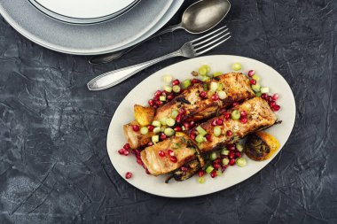 Mutfak masasında nar ve tavada kızartılmış somon balığı. Düz yatıyordu