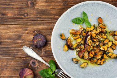 İncir soslu kabuklu midye, tabakta kızarmış midye. Deniz ürünleri, pişmiş midyeler..