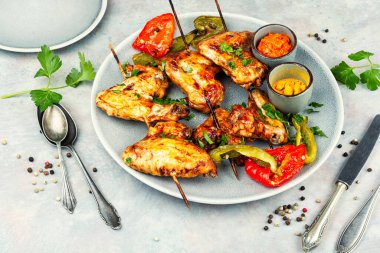 Tahta şişler üzerinde çıtır çıtır derili sulu tavuk kanatları..