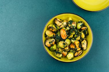 Kızarmış Brüksel lahanası, midye, sarımsak ve ıspanak salatası. Uzayı kopyala Metin için boşluk.