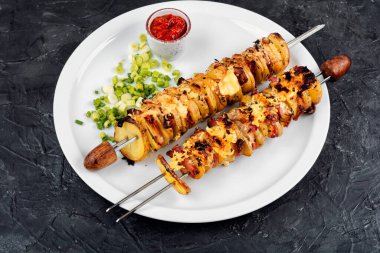 Mutfak masasında servis edilen domuz pastırmasına sarılmış patates şişleri. Pişirme ve ızgara için ev yapımı lezzetli yemekler..