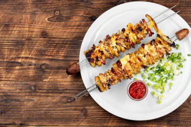 Mutfak masasında servis edilen domuz pastırmasına sarılmış patates şişleri. Pişirme ve ızgara için ev yapımı lezzetli yemekler..