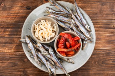 Seramik tabağa yerleştirilmiş kurutulmuş balık aperatifleri..